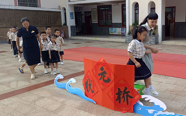 2024年9月2日南宁市华西路小学“开笔破蒙  立德明志”开笔礼活动中，冯霞校长带领一年新生走过状元桥。.jpg