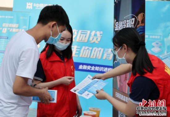 图为志愿者发放金融知识宣传资料。　张雅露 摄